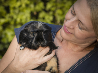 The founder of Mutt and Manor gently holds a black guinea pig